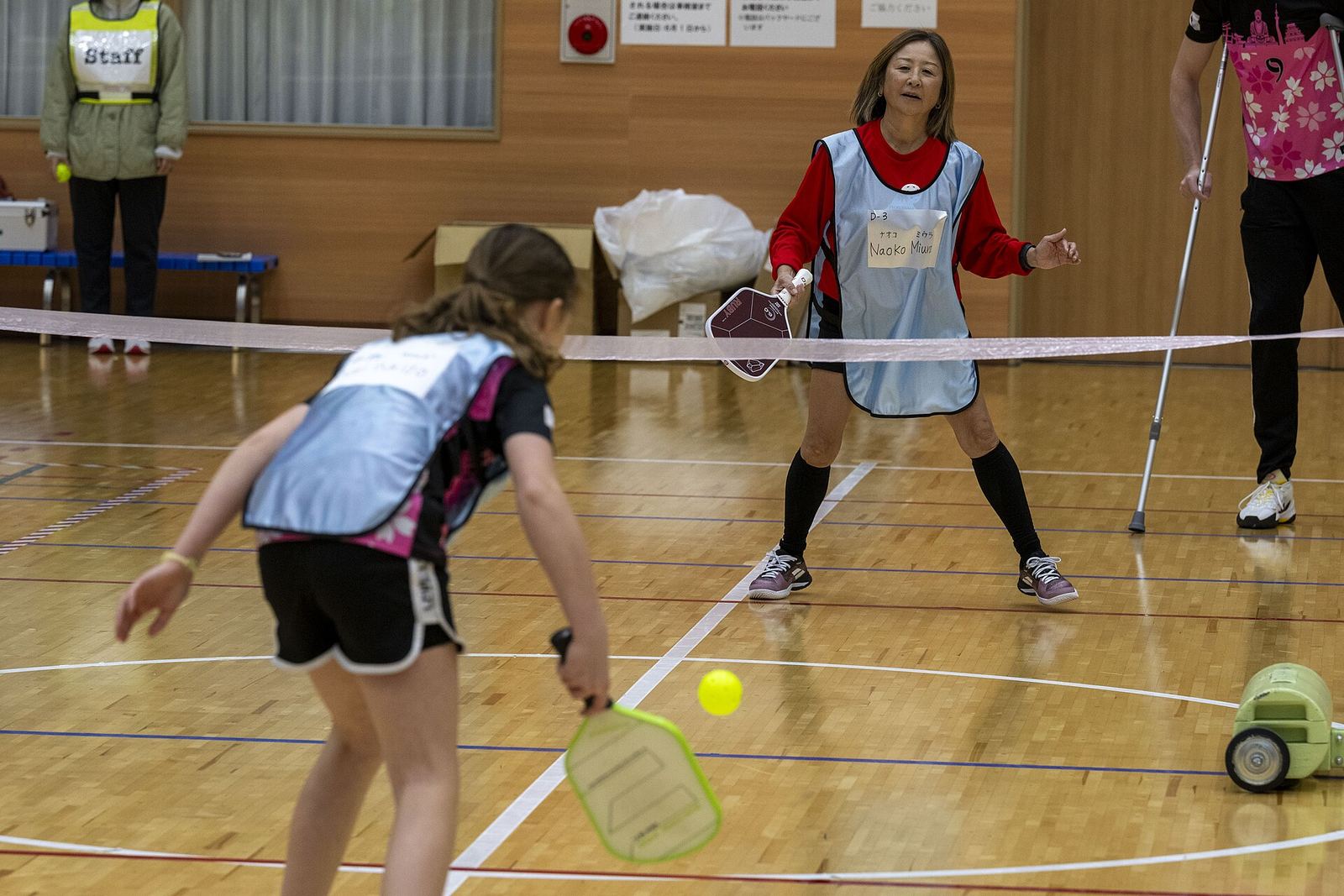 A young player returns a shot at the net during a community pickleball rally